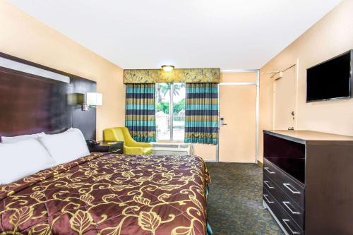 um quarto de hotel com uma cama e uma televisão em Days Inn by Wyndham Fort Lauderdale Airport Cruise Port em Fort Lauderdale