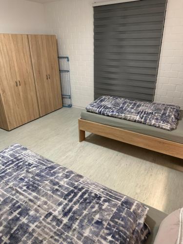 una camera con due letti e un armadietto in legno di 2 Zimmer Whg a Langelsheim
