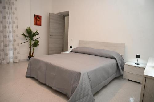 ein weißes Schlafzimmer mit einem großen Bett und einer Pflanze in der Unterkunft Casa Fea in Vietri