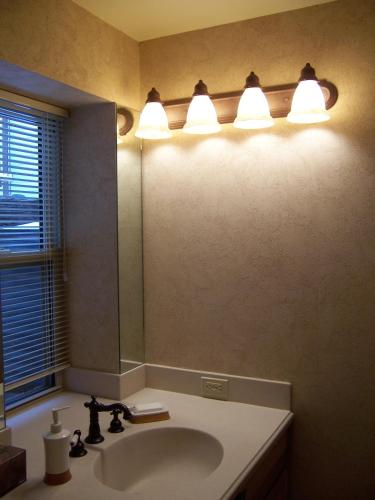 a bathroom with a sink and lights above a mirror at K3 Guest Ranch in Cody