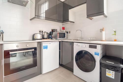 uma cozinha com uma máquina de lavar roupa e uma máquina de lavar roupa em Central Dublin Apartment em Dublin