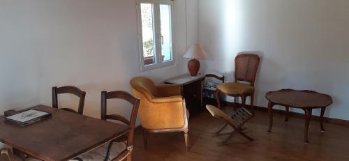 a living room with chairs and tables and a window at Maison de Campagne l'étang in Seillans