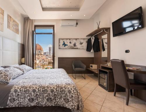 um quarto com uma cama, uma secretária e uma janela em Hotel Bellavista em Florença