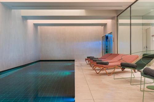 een zwembad met een rij stoelen en een zwembad bij LUSTER Hotel in Lissabon