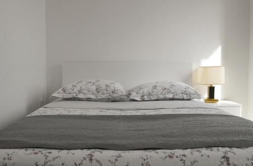 1 dormitorio con 1 cama con 2 almohadas y lámpara en Holiday Home Romana, en Tribunj