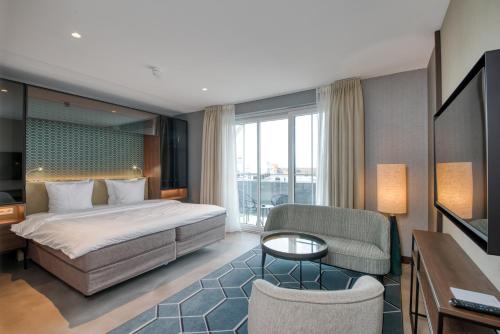 a hotel room with a bed and a table and chairs at Hotel de Schelde in Cadzand-Bad
