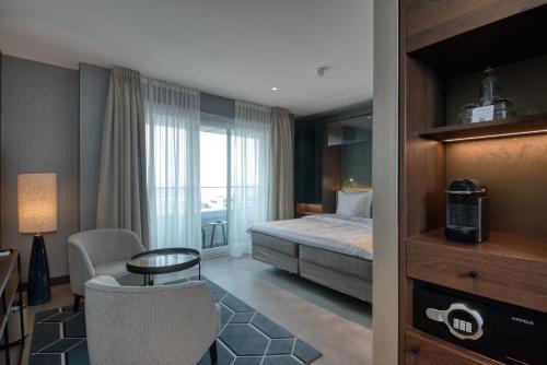 a hotel room with a bed and a desk and a chair at Hotel de Schelde in Cadzand-Bad