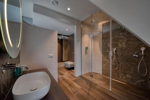 ein Bad mit einer Dusche, einem WC und einem Waschbecken in der Unterkunft Hotel de Schelde in Cadzand-Bad