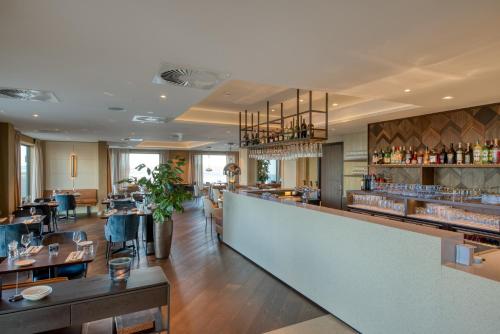 a restaurant with a counter and a bar at Hotel de Schelde in Cadzand-Bad