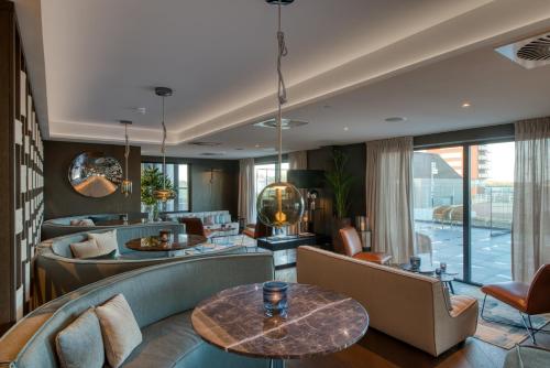 a living room with couches and a table at Hotel de Schelde in Cadzand-Bad
