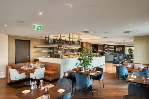 a restaurant with tables and chairs and a bar at Hotel de Schelde in Cadzand-Bad