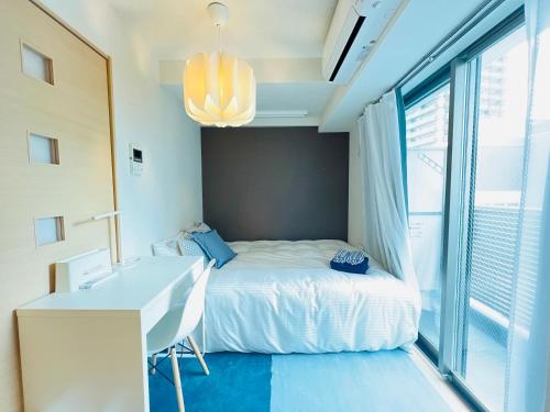 a bedroom with a bed and a desk and a window at Nishishinjuku 902-SJ0367 in Tokyo