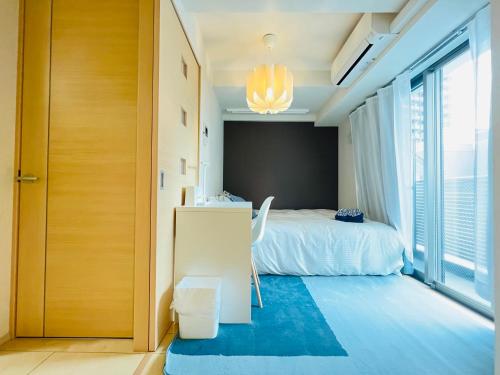 Un dormitorio con una cama y una ventana grande. en Nishishinjuku 902, en Tokio