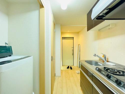 a small kitchen with a sink and a stove at Nishishinjuku 902-SJ0367 in Tokyo