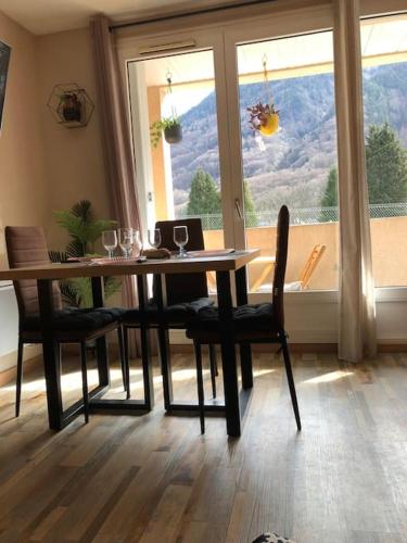 une salle à manger avec une table et des chaises et une fenêtre dans l'établissement Appartement 4 personnes vue sur la montagne, à Cauterets