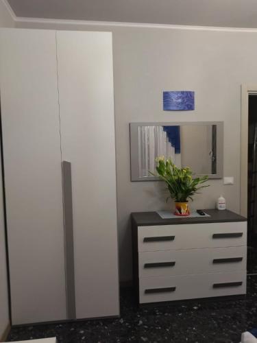 a white dresser with a mirror and a plant on it at La Casa di Sonia in Savona