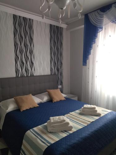 a bedroom with a blue bed with towels on it at La Casa di Sonia in Savona