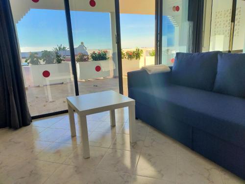 a living room with a blue couch and a table at Wohnung Sabina in Agüimes