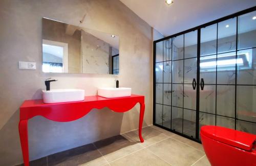 a red bathroom with two sinks and a mirror at Astonis in Belek