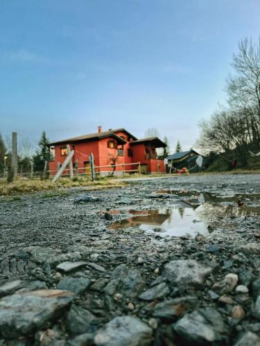 a house in the background of a rocky road with a building at Apartaments Cel i Fusta in Camprodon