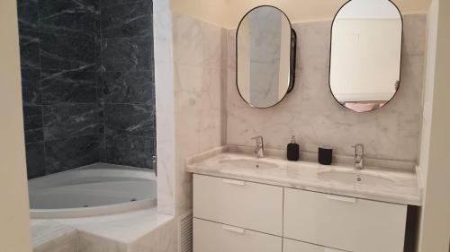 La salle de bains est pourvue de 2 lavabos, d'une baignoire et de 2 miroirs. dans l'établissement Luxury Apartment Los Olivos HK - 99 HDA Golf Resort, à Fuente Alamo