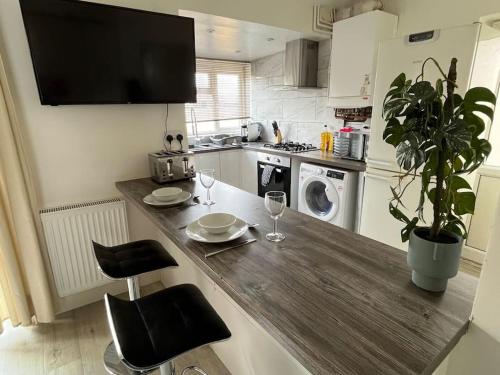 a kitchen with a wooden counter top with two wine glasses at Modern 4-bed house with garden & parking in Walsgrave on Sowe