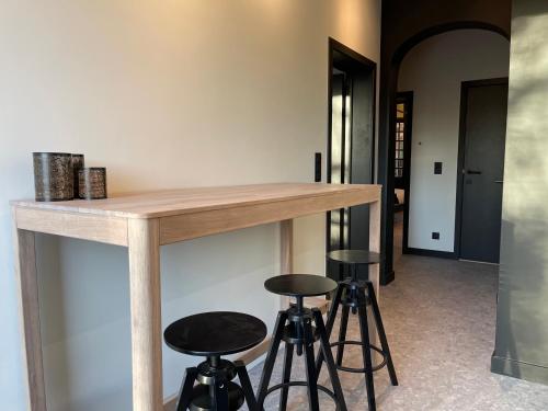 a kitchen with a wooden counter and stools at 3 Bedroom Art-Nouveau Apartment with Free Parking in Ghent