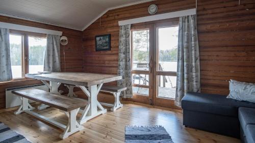 sala de estar con mesa y sofá en Myllyjärven mökki, en Fiskars