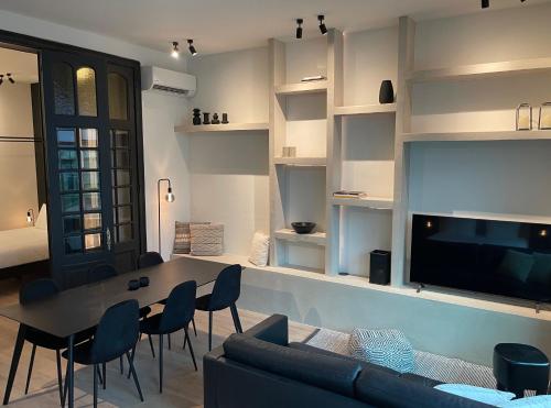 a living room with a table and chairs and a tv at 3 Bedroom Art-Nouveau Apartment with Free Parking in Ghent