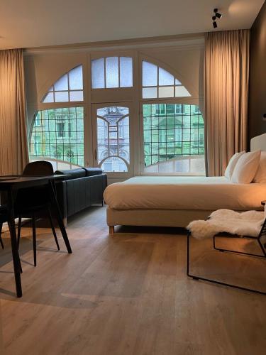 a bedroom with a bed and a piano and a desk at 3 Bedroom Art-Nouveau Apartment with Free Parking in Ghent