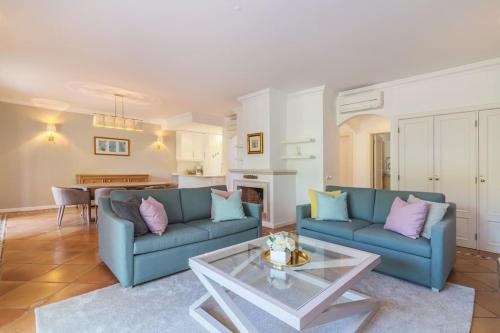 ein Wohnzimmer mit 2 blauen Sofas und einem Tisch in der Unterkunft Moradia Geminada com 2 Quartos Quinta do Lago in Quinta do Lago