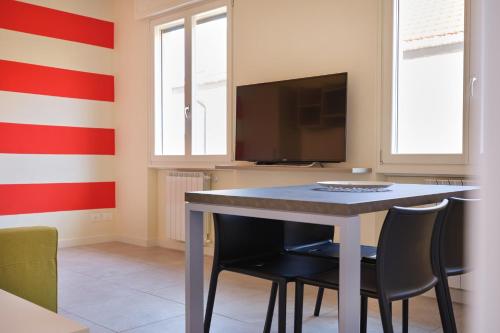 a dining room with a table and chairs and a tv at Casa Ierardi - Appartamento Meina in Meina