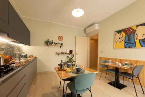 een keuken en eetkamer met 2 tafels en stoelen bij Dimora Lauro in Gagliano del Capo