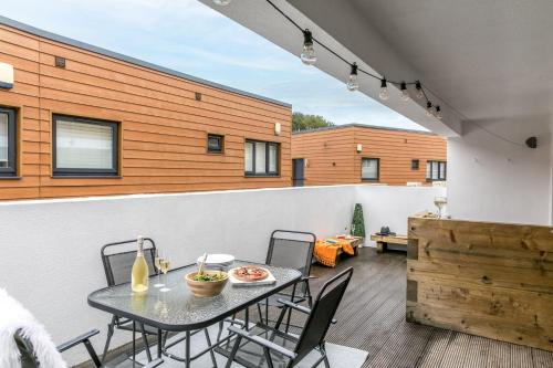 a patio with a table and chairs on a building at Plover 1, The Cove - On site pool - Wi-Fi in Brixham