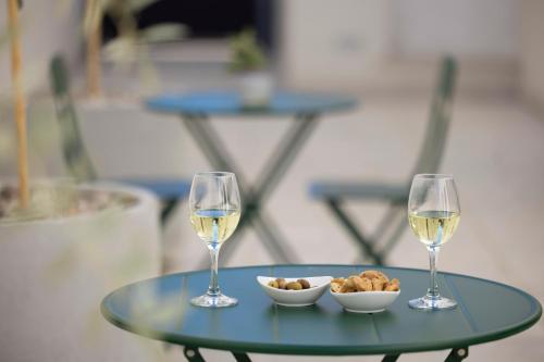 two glasses of wine and a bowl of food on a table at Dimora Lauro in Gagliano del Capo