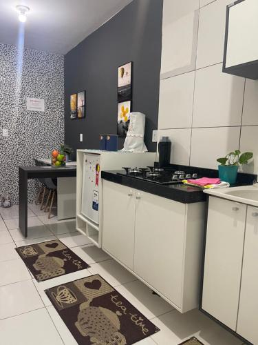 a kitchen with white cabinets and a table at Flat JK 102 in Juazeiro do Norte