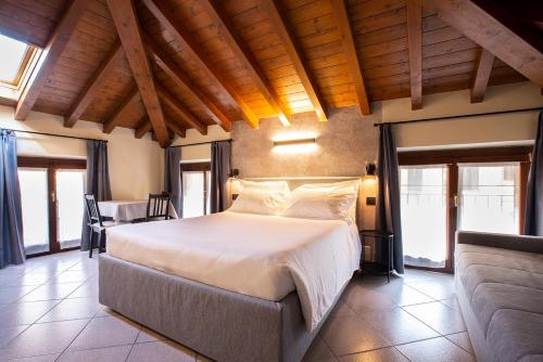 a bedroom with a large bed in a room with windows at Antico Pozzo Apartment in Bellagio