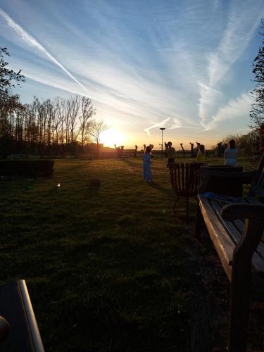 a group of people in a park at sunset at B&B Hullebrug in Heist-op-den-Berg