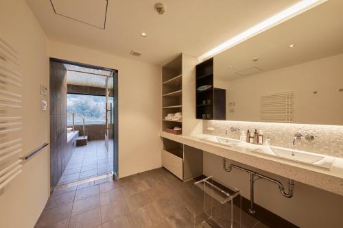 a bathroom with two sinks and a large mirror at River Retreat Garaku in Toyama