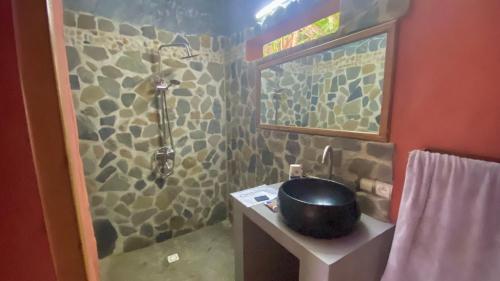 a bathroom with a shower and a bowl on a sink at VERONIKA Resort Nosy Komba in Nosy Komba