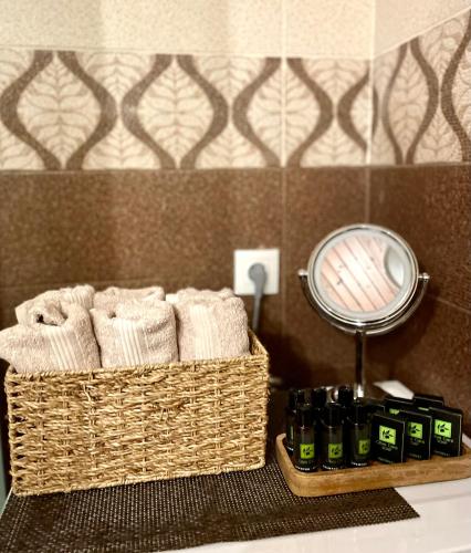 a basket of towels and a mirror on a bathroom sink at The Odyssey Holiday Home - Agios Ioannis, Pelion in Agios Ioannis Pelio