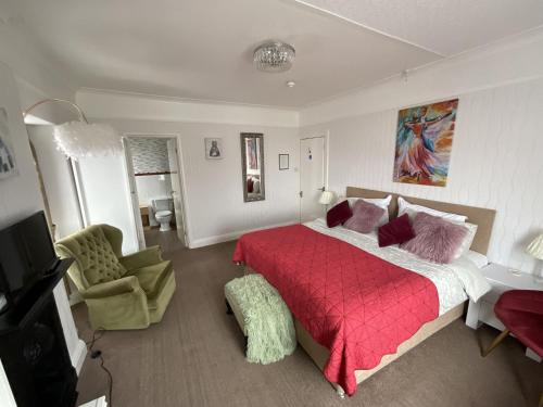 a bedroom with a large bed with a red blanket at Pendrin Guest House in Tintagel
