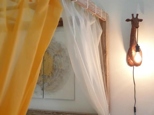 a room with a window with white curtains at La Casetta di Zoe Apartment in Molfetta