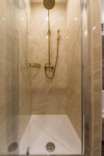 a shower with a glass door in a bathroom at Design Apartment on Mykhailivskyi Ln. 4 in Kyiv