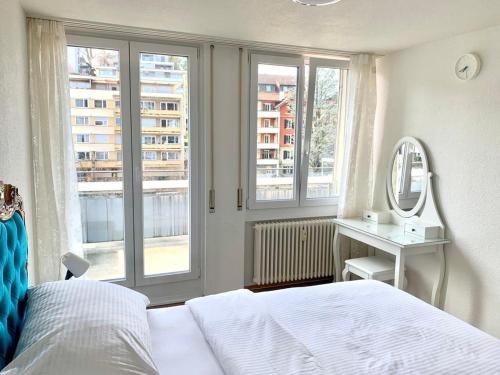 a bedroom with a bed and a mirror and windows at Hawa Apartment - two balcony - by PA in Lucerne
