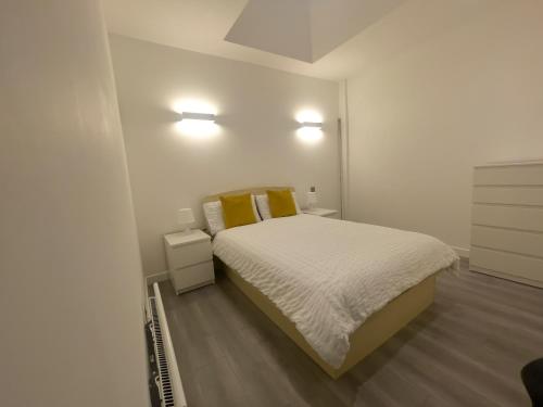 een witte slaapkamer met een bed en twee nachtkastjes bij Lovely 2 Double Bedroom Flat with free parking - At the Atrium MK in Milton Keynes
