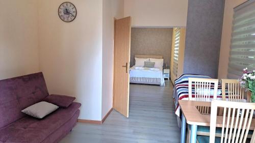 ein Wohnzimmer mit einem Sofa, einem Tisch und einem Bett in der Unterkunft Sobe Apartmani Svitlana in Sukošan