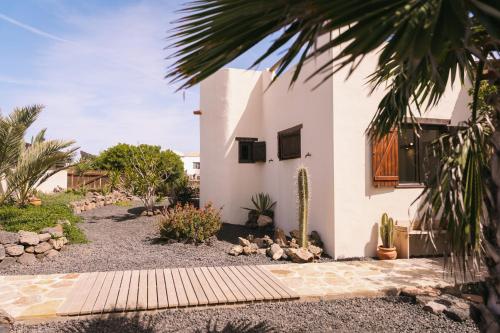 a white house with a yard with cactus at Casa Maja in Lajares