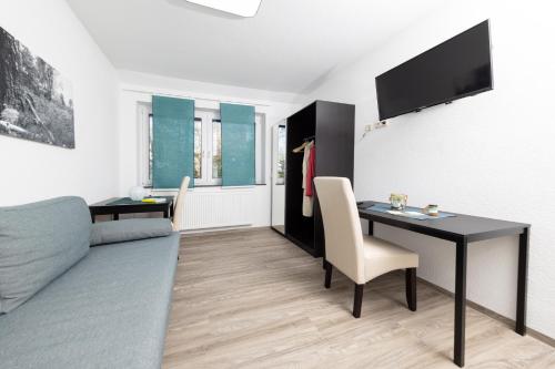 a living room with a table and a couch at Hotel Ehlers in Schneverdingen