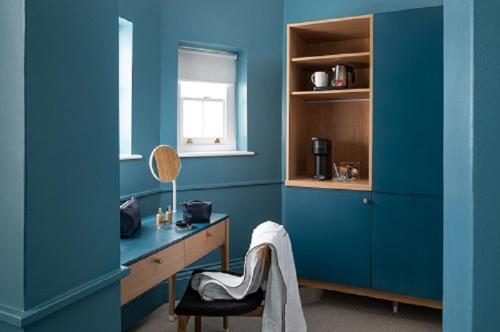 a blue room with a desk and a chair at The Goodenough Hotel London in London